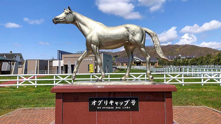 北海道新冠町の優駿記念館にあるオグリキャップ号像：優駿メモリアルパーク正面に立ち、来場者を迎える平成の怪物・オグリキャップの等身大ブロンズ像です。