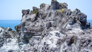 山形県遊佐町の十六羅漢岩：日本海に突き出た岩礁に、地元の和尚らが海上安全などを祈願して刻んだ22体の磨崖仏（十六羅漢）。